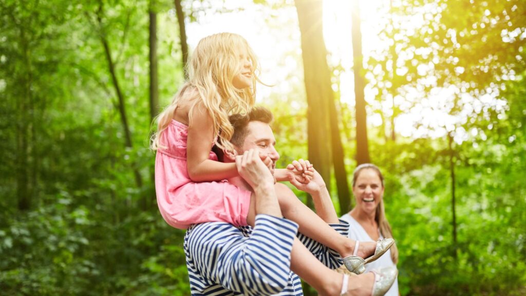 dad carrying daughter on shoulders