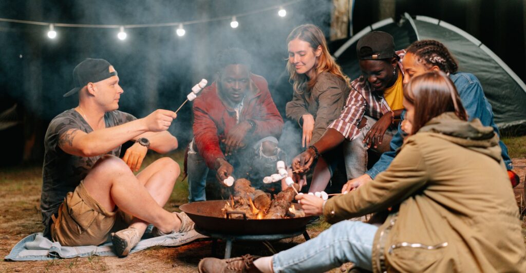 friends cooking at campfire