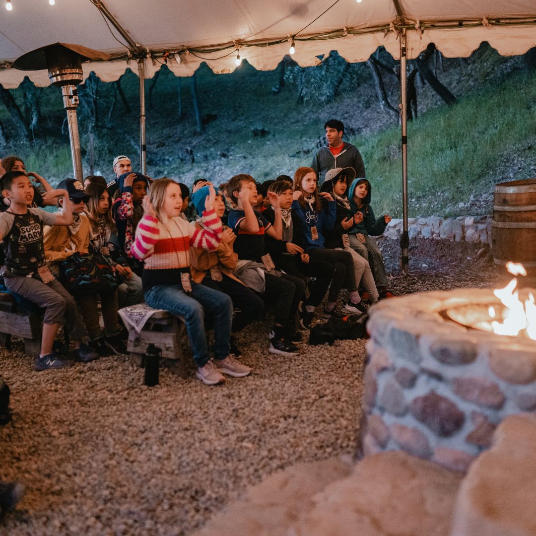 kids sitting around a campfire together