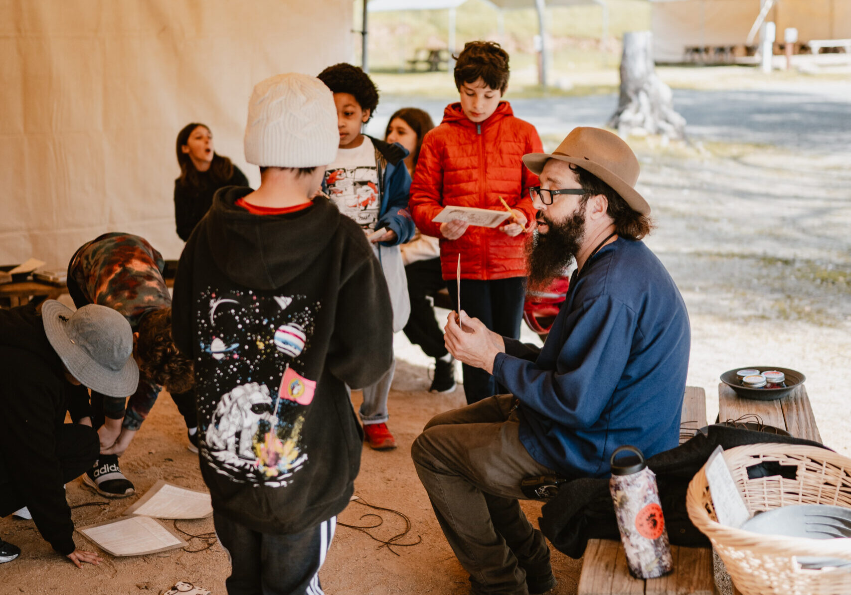 kids inside of tent talking to camp leader